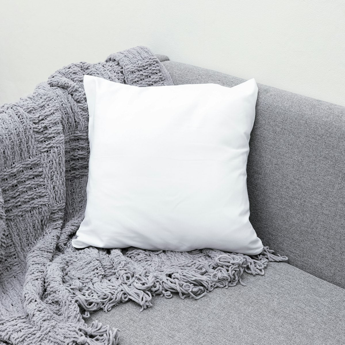 White throw pillow on a gray sofa