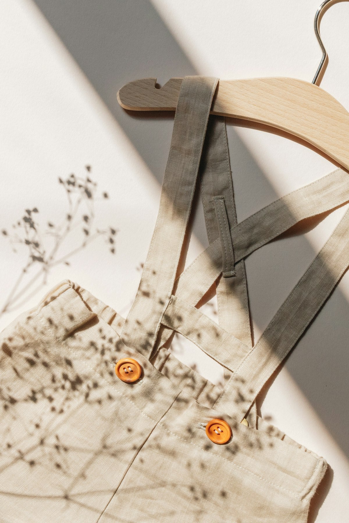 Wooden hanger holding scissors near clothes