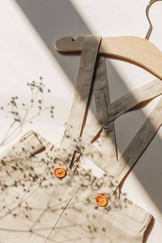 Wooden hanger holding scissors near clothes